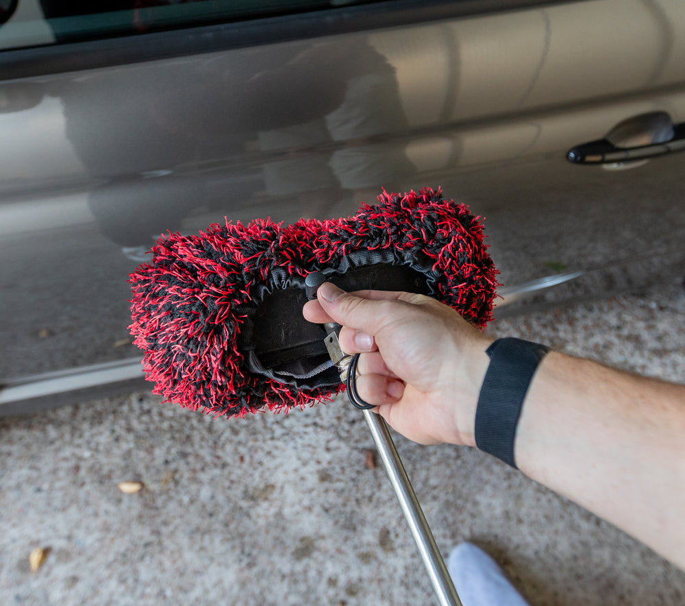 Brush Cover aus schwarz-roter Mikrofaser wird am Kopf einer Waschbürste befestigt
