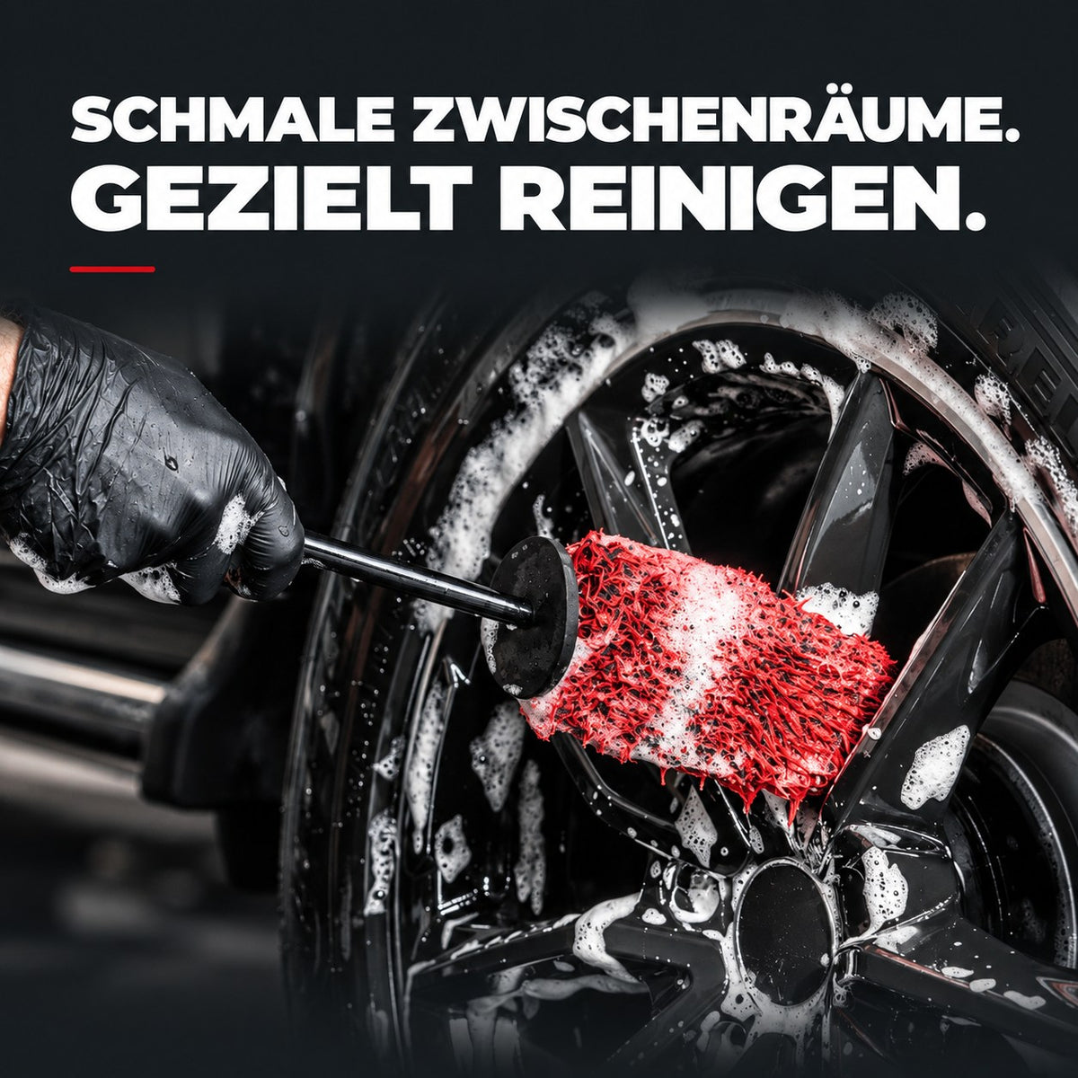 Flache Safe-Shield Felgenbürste mit rotem Mikrofaserbezug beim Reinigen der Zwischenräume einer eingeschäumten Felge.